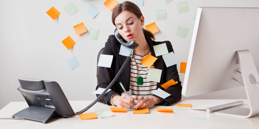 Studio shot of young woman working in office covered with adhesive notes